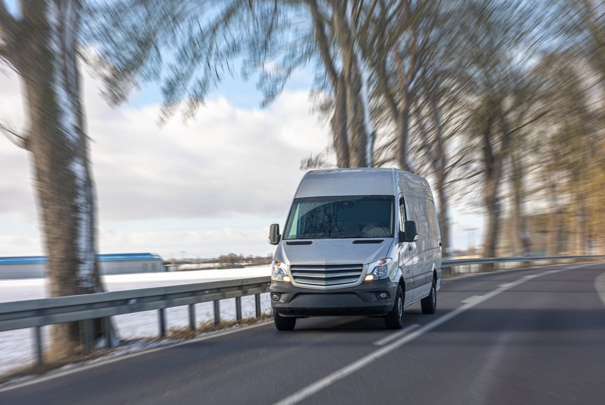Cargo van driving along a snowy road